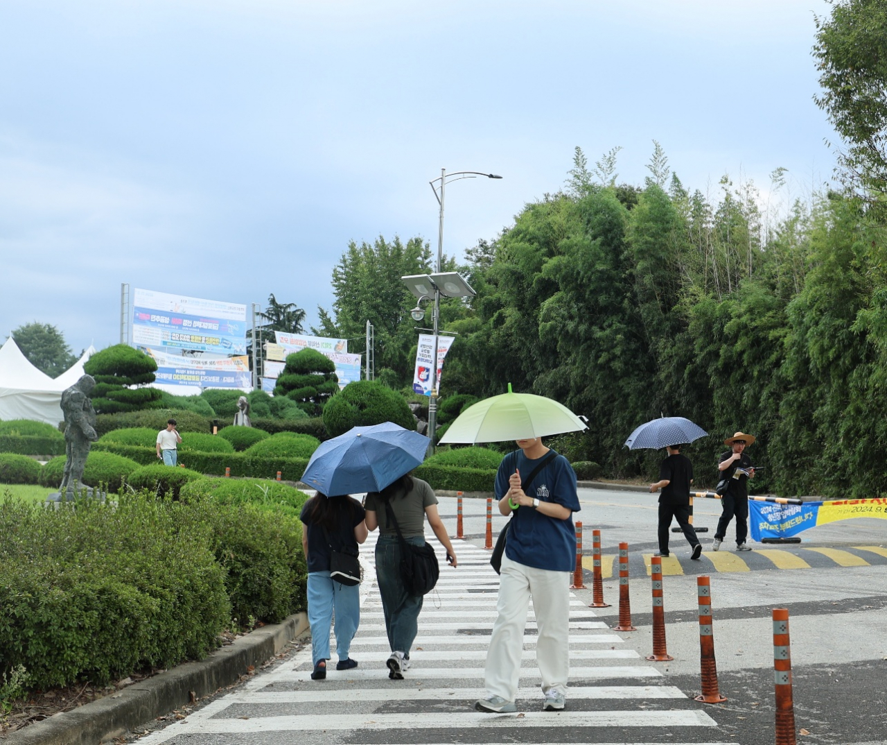 전북 전역에 늦더위가 이어지고 있는 가운데 11일 익산 한 대학교에서 갑작스럽게 쏟아진 소나기에 학생들이 우산을 쓴 채 이동하고 있다.   채윤정 기자